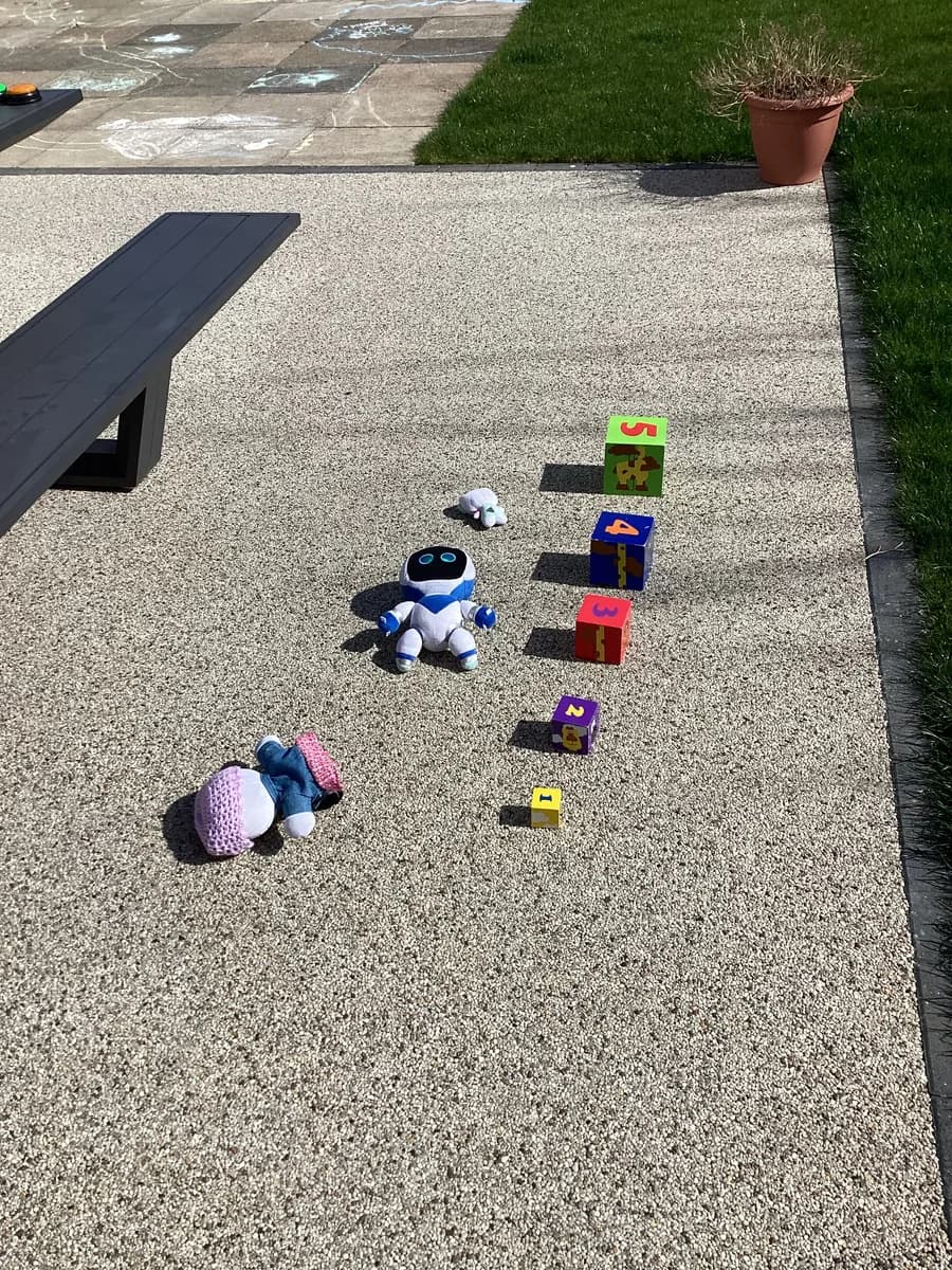 Number blocks lined up beside toy characters on the garden path