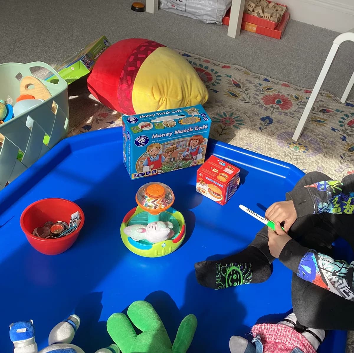 Play food, coins and a shopping game arranged on a blue tray
